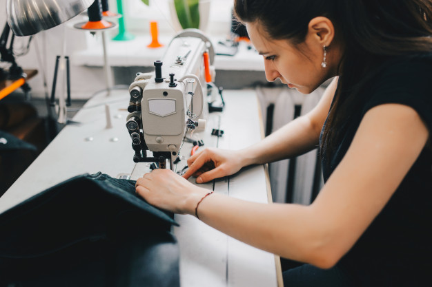 female-artisan-threading-black-leather-sewing-machine_8353-6069