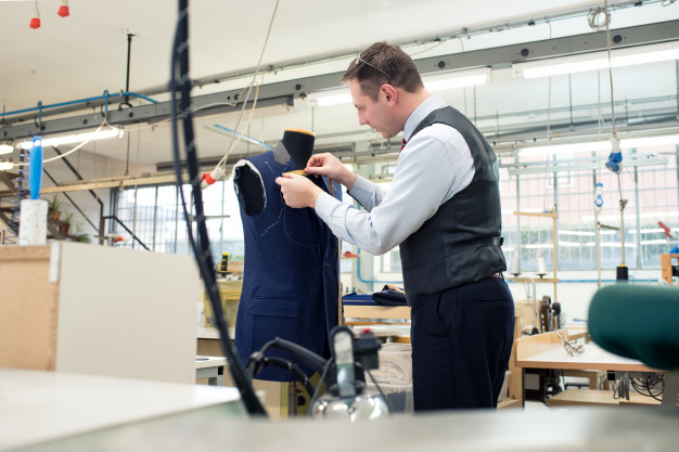 tailor-standing-working-blue-jacket_126745-86